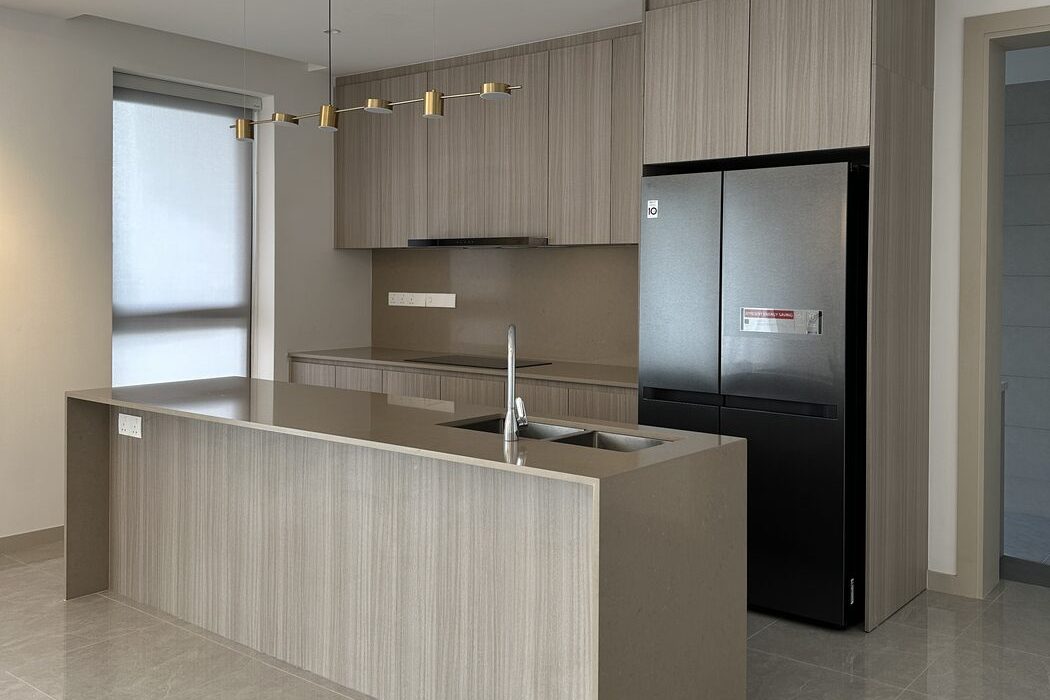 Kitchen with a wood-grain island, wall cabinets and a tall fridge in a Sunpina home